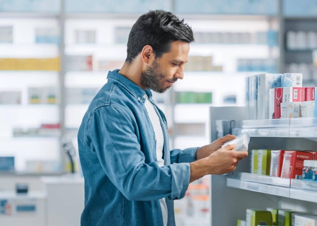 A man picking a box of treatment up off the shelf.