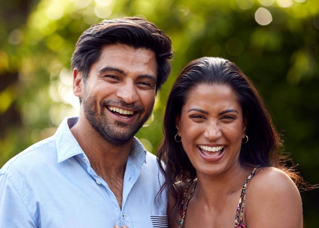 A happy couple looking at the camera.